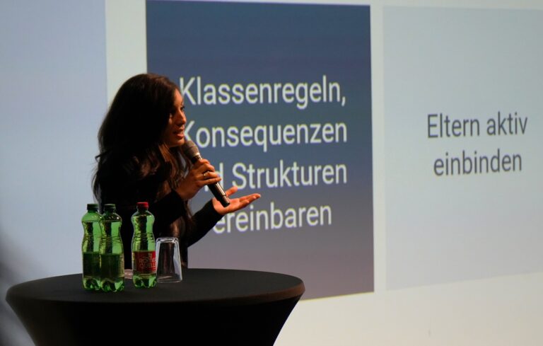 COOL Lab Mitarbeiterin Marina auf einer Bühne vor einer Präsentation.